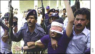Pakistan police with arrested man