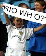 A Leeds fan holds aloft a banner
