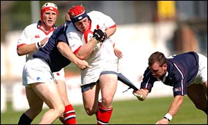 Ulster's Neil McMillan is tackled by Swansea's Shaun Payne (left) and Dean Thomas