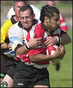 Caerphilly's Sione Tuipolotu is tackled by Ebbw's Ockert Booyse