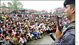 An election rally with soldier in the foreground