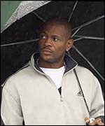 Maurice Greene shelters under an umbrella