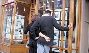 A couple looking in an estate agents window