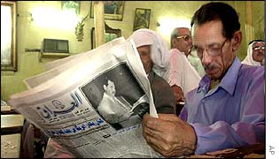 Man reading newspaper Al-Iraq newspaper in Baghdad