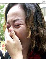 Unidentified family members of a Japanese kidnapped by North Korea weep during a protest
