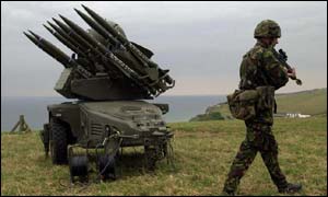 An RAF Regiment Sergeant walks past a Rapier Missile