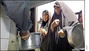 Iraqi women receive monthly food rations from a local mosque in Baghdad 
