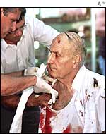 An old man being treated by paramedics