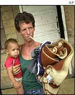 Woman and child hold possessions as they prepare to evacuate