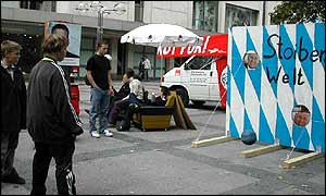 Would-be voters have a go at kicking a football through a poster of candidate Edmund Stoiber