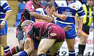 Brocklehurst is tackled by the Leeds defence