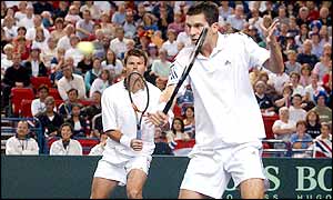 Tim Henman returns the ball as both sides start the doubles match well