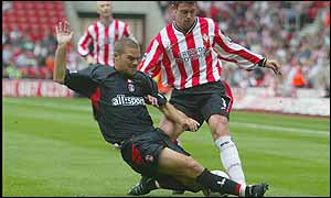 Charlton full-back Luke Moore slides in on Saints' defender Wayne Bridge