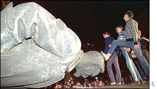 A demonstrator steps on the head of the Dzerzhinsky statue