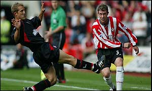 Wayne Bridge of Southampton (right) crosses in past John Robinson of Charlton