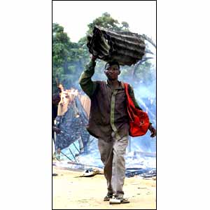 A man carrying sheets of corrugated iron [picture: AP]