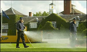 Ground staff spray the green at the tenth hole