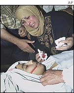 Sahar Albahsh over the body of her 13-year-old son 