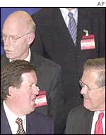 Peter Struck (top left) and Donald Rumsfeld (bottom right) ignore each other