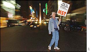 A demonstrator carries a sign reading 