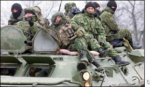 Russian soldiers ride on an armoured personnel carrier into Chechnya from Ingushetia