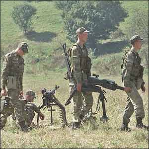 Russian soldiers carry a grenade launcher after the battle