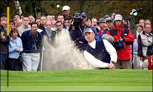 Duval keeps a close eye on his ball as he chips out of the bunker at the first