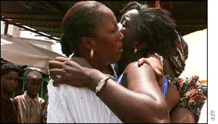 Two woman embrace as they await news of the missing passengers
