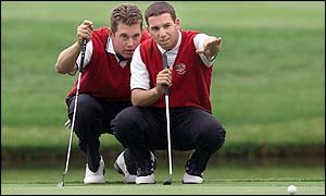Lee Westwood and Sergio Garcia line-up a putt during their foursomes match