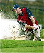Jim Furyk plays out of a sand trap at the ninth