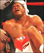 Riddick Bowe clutches his groin after being hit low by Andrew Golota