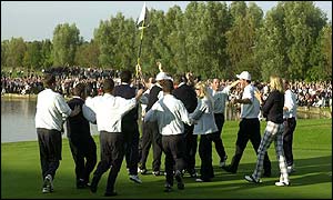 Paul McGinley is mobbed by his team-mates after winning