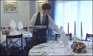 Restaurant waiter laying a table.
