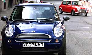 Two Mini motor cars parked in a street.