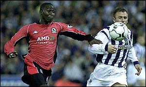 Blackburn forward Andy Cole powers past West Brom defender Ronnie Wallwork