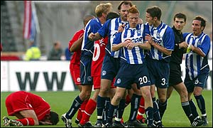 Zecke (centre) is pulled clear after leaving Phil McGuire with a sore face