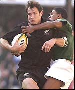 All Black Leon MacDonald is tackled by South Africa's Breyton Paulse
