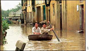 Vietnamese men paddle their way down a street in a basket in Hoi An in Quang Nam province in central Vietnam, 1999 