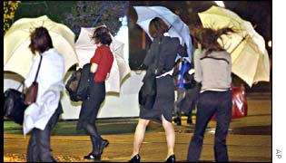 Women in Yokohama have their umbrellas caught by storm-force winds