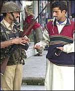 Soldier checking Kashmiri man