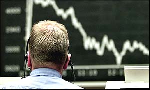A stock market trader looking at a board showing a market that has fallen