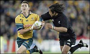 New Zealand centre Tana Umaga tries to stop Australia wing Mat Rogers