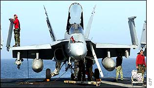 Crew members prepare an F-18 fighter on the flight deck of the nuclear-powered aircraft carrier USS Abraham Lincoln deployed in the Arabian Sea 
