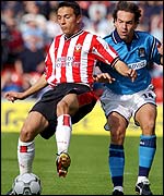 Fabrice Fernandes shields the ball from Eyal Berkovic