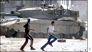 Palestinian boys in front of an Israeli tank in Nablus