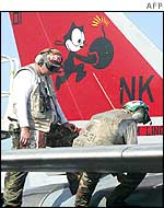 Sailors clean an F-14 fighter jet on board the USS Abraham Lincoln