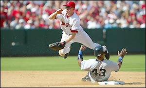 Anaheim's David Eckstein leaps over Raul Mondesi as he sends the ball back to first base for a double play 