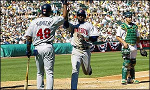 Cristian Guzman (left) records three hits for the Twins, who began the series as underdogs