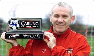 Reid poses with the manager of the month award for December 2000