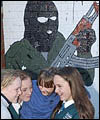 Schoolgirls play in front of an IRA Mural in Belfast